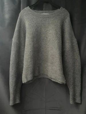 Grå stickad tröja från Zara - Mysig grå stickad tröja från Zara med avslappnad passform och rund halsringning. Perfekt för lager på lager och enkel att matcha till olika outfits.