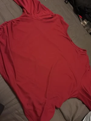 Mörkröd långärmad topp - En enkel och stilren mörkröd långärmad topp med rund halsringning. Perfekt att matcha med jeans eller kjol för en snygg vardagslook. Tunn och mjuk i materialet, vilket gör den skön att bära.