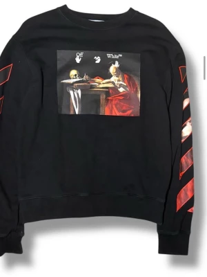 Off-White svart sweatshirt med print - Svart sweatshirt från Off-White med konstnärligt print på bröstet och röda detaljer på ärmarna. Rund halsringning och ribbade muddar. Snygg streetwear med unik design och Off-White-logga.