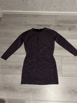 Glittrig mörk långärmad klänning - Snygg mörk klänning med glittereffekt och lång ärm. Perfekt till fester. Använd en gång. Stl KIDS 146/152 10-12 år, även passande för XXS/XS