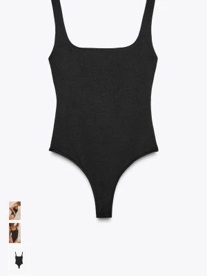 Svart ribbad body med breda axelband - Snygg svart body med breda axelband och fyrkantig ringning. Tillverkad i ett ribbat stretchmaterial som sitter tight och bekvämt mot kroppen. Perfekt att styla med jeans eller kjol för en clean look.