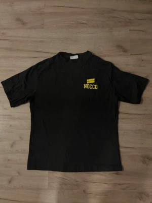 EXTREMT SÄLLSYNT Svart NOCCO t-shirt  - Svart NOCCO-t-shirt i mjuk bomull med gul logga på bröstet och stort “TIME TO FOCUS”-tryck på ryggen. Extremt sällsynt modell som producerats i mycket begränsat antal – finns endast ett fåtal exemplar. Ett unikt plagg för samlare och NOCCO-fans. BUDGIVNING AKTIV, PRIS GÅR ATT DISKUTERA