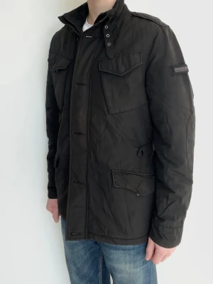 Woolrich Field jacka - Snygg och eftertraktad field jacka från Woolrich! Fint skick inga defekter. Storlek M (EU), modellen är ca 182, 70kg. Kontakta mig för fler frågor och funderingar!