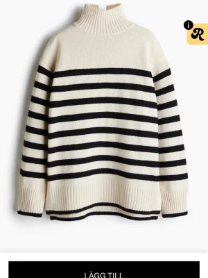 Randig stickad tröja med polokrage - Snygg stickad tröja i vitt med svarta horisontella ränder och hög polokrage. Tröjan har långa ärmar och breda ribbstickade muddar vid ärmslut och nederkant. Perfekt för en trendig och avslappnad look.