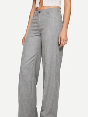 Ljusgrå vida kostymbyxor - Snygga ljusgrå kostymbyxor med hög midja och vida ben. Byxorna har klassisk knapp och dragkedja framtill samt hällor för skärp. Perfekta för en stilren look och lätta att matcha med olika toppar. Använda ca 1 gång. Storlek 34. Använda ca 1 gång 