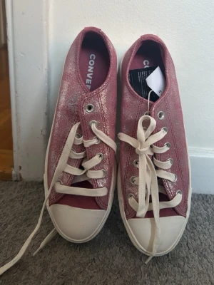 Rosa glittriga Converse sneakers - Säljer ett par rosa glittriga Converse sneakers med vita gummisulor. Skorna har en lite högre sula än den klassiska modellen. 💕💕