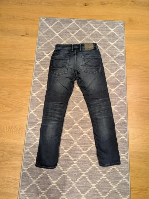 Mörkblå jeans från Jack & Jones - Snygga mörkblå jeans från Jack & Jones. Modellen är Slim Fit/Tim och byxorna är i storleken 28/32. Byxorna är i lite mjukare jeans material mer som Replay byxor! Byxorna är i mycket fint skick! Kontakta gärna vid frågor😊