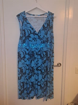 2000tals klännning - Klänning med blommigt mönster, paljetter och knytning baktill. Fin att ha för sig eller över jeans. Str 46/48 🩷