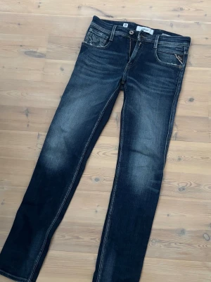 Mörkblå jeans från Replay - Snygga mörkblå jeans från Replay med schyssta slitningar på låren och vid fickorna . Jeansen har inga skador eller hål och är perfekta att rocka nu till våren.