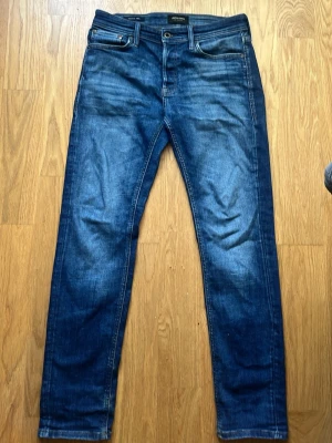 Jack & Jones jeans W29 L32 – slim fit – blå denim (Mycket bra Skick) - Snygga blå jeans från Jack & Jones (Jeans Intelligence). Klassisk denim med lätt slitning/fade som ger en snygg look. Bekväma och passar till både vardag och mer uppklätt.