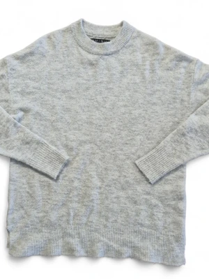 Ljusgrå stickad tröja från Amisu - Mysig ljusgrå stickad tröja från Amisu med rund halsringning och ribbade muddar vid ärmslut och nederkant. Tröjan har en avslappnad passform och är perfekt för lager på lager. Tillverkad i mjukt material som känns skönt mot huden.