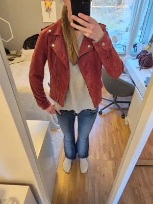 Röd skinnjacka med dragkedjor - Säljer min absoluta favorit skinnjacka i bikerstil med flera silverfärgade dragkedjor och axelklaffar. Jackan har en klassisk krage och detaljerade sömmar som ger en jätte cool look. En ny sådan jacka kostar upp mot 1300 kr. Säljer då den blivit förliten💔😔 Skriv för frågor!🌸(Liten I storlek då jag som brukar ha storlek s-m tycker att denna i storlek L är förliten i ärmarna. Har dock långa armar)