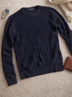Mörkblå kabelstickad tröja Riley - Kabelstickad mörkblå tröja från Riley med rund halsringning och ribbade muddar. Tröjan har lång ärm och klassisk passform, perfekt för lager på lager under kyliga dagar. Snygg struktur i materialet som ger en stilren look.   NYPRIS: 900kr