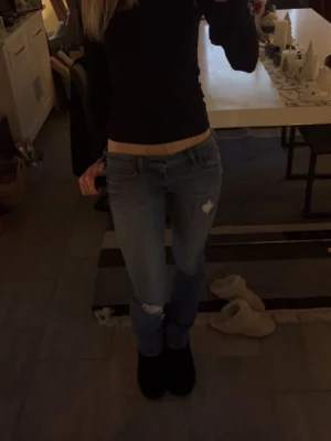 Holister jeans med coola slitningar - Säljer mina hollister jeans då dem är lite för korta, jag är 172 som referens. Dem ör använda fåtal gånger men har ett hål på bakfickan från förra ägaren men inget som gör igen jeansen så utan bara på ytterfickan! Dem är bootcut och sitter som en S.