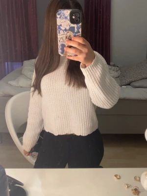 Vit stickad tröja med breda ärmar - Säljer en vit stickad tröja med breda, långa ärmar och ribbstickade muddar. Tröjan har en avslappnad passform och är gjord i ett mjukt, grovt stickat material. Jättesnygg till sommaren med en svart kjol till exempel på kvällarna. Det finns dock lite lila färg på den men stans knappast inte alls, kameran fick inte upp det heller och det är inget man tänker på !! Det är i storlek 146 men passar xxs/xs/s som jag har 