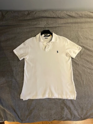 Vit pikétröja från Ralph Lauren - Klassisk vit pikétröja från Ralph Lauren. Storlek: Small. Endast använd ett fåtal gånger, därför är den i nästan helt perfekt skick. Nypris ≈ 1500kr. Mitt pris = 450kr. Riktigt schysst om du vill ha en nästan helt ny pike för en tredjedel av priset!