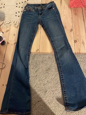 Blå bootcut jeans från True Religion - Säljer ett par jeans från true religion använda några gånger men inte mycket men dom märker man av alls i modellen Becca och är mid waist  w23 pris kan diskuteras 