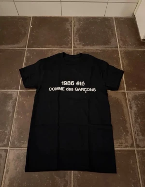 Commes des garcons t shirt  - Riktigt fet och eftertraktad t-shirt med commes des garcons loggan i storlek S. Väldigt bra skick!  Obs: Jag är lite osäker på äktheten då lappen i nacken saknas, därför säljs den billigare (499 kr, nypris ca 3000 kr).  längd cirka 65cm, bredd cirka 44cm. Tveka inte att höra av dig vid frågor eller funderingar!