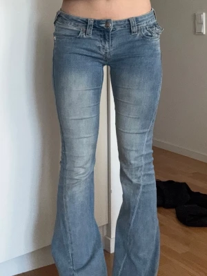 Joey jeans från True Religion - Säljer ett par ljusblå joey jeans från True Religion. Jeansen är lågmidjade! De är i superfint skick, en ytterst liten defekt på längderna som är lite slitna, se sista bilden. De är i storlek 26 vilket motsvarar ungefär S, funkar för mig som är mellan XS och S. Perfekta i längden på mig som är 171cm lång. Skriv om du har några frågor, priset kan absolut diskuteras!💞