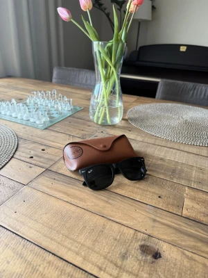 Ray-Ban Solglasögon  - Säljer ett par Ray-Ban solglasögon i modellen Wayfarer. Fodral, duk och original box följer med. I princip oanvända!