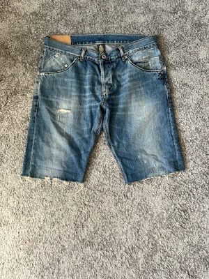 Dondup jeansshorts - Säljer nu mina dondup shorts då jag tyvärr växt ur dem. Väldigt snygga slitningar och snygg tvätt. Väldigt bra skick. Storlek 35 men sitter som 32 i midjan. Pris 299 prutat o klart!