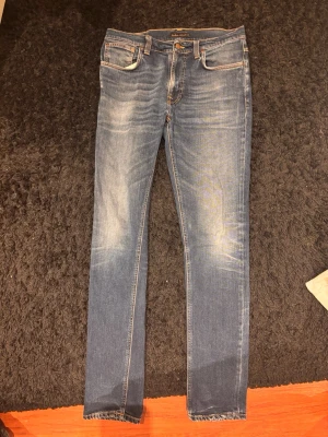 Blå slim fit jeans från nudie - Snygga blå slim fit jeans från Nudie i modellen lean Dean med klassisk femficksdesign med en riktigt snygg fade där fram. Perfekta för en trendig och avslappnad look. Materialet är mjukt och stretchigt för extra komfort (100% organic cotton). Priset inte hugget i sten, hör av dig vid minsta fråga!