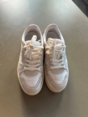 Axel arigato dam Vita sneakers - Stilrena vita sneakers i fint skick 🤍 Snygga och bekväma sneakers som passar till det mesta. Använda men väl omhändertagna, med mindre bruksspår (se bild). Perfekta till både vardag och en mer uppklädd look. Axel arigato i storlek 37. Nypris 2800