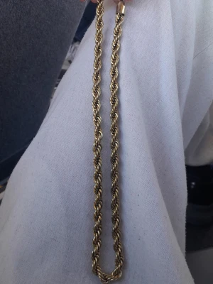 Guld tvinnat halsband - Snyggt guld halsband med tvinnad kedja som ger en cool och trendig look. Halsbandet har en klassisk design och passar perfekt till att lyfta vilken outfit som helst.