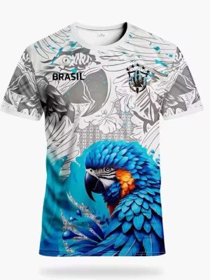 Färgstark Brasilien t-shirt med papegoja - Unik t-shirt med stort tryck av en blå papegoja och grafiska mönster i vitt, grått och blått. Texten 'BRASIL' och ett emblem på bröstet. T-shirten har rund hals, korta ärmar och är tillverkad i mjuk polyester. Perfekt för dig som gillar färg och statement-plagg.