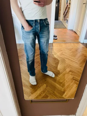 Replay jeans  - Replay jeans | Slitningar och hål där bak vilket man ser på bild 4 | Enligt mig gör slitningarna och skicket jeansen riktigt snygga, det är ganska eftertraktat med färdig producerade håliga jeans| Storlek: W31 L32. Passform: slim/regular, modell står ej 