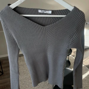 Grått ribbat set  från NA-KD - Säljer ett set i form av en stilren grå ribbad tröja tillsammans med en långkjol från NA-KD! Köpt från Vinted men aldrig använd av mig men i bra skick! Litet hål bak där lappen suttit men inget som syns vid användning (se bild) 😇