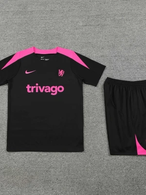 Chelsea svart och rosa träningsset Nike - Chelsea träningsset med svart t-shirt och shorts, båda med rosa detaljer. Tröjan har rosa Nike-logga, klubbmärke och 'trivago' tryck framtill. Tillverkad i lätt och ventilerande material, perfekt för fotbollsträning eller gym.