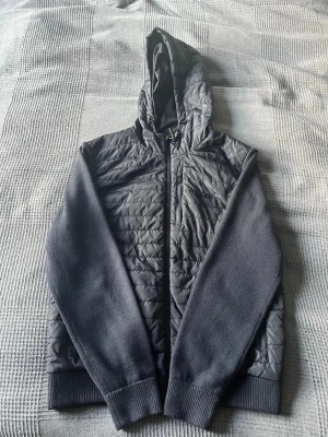 J Lindeberg cardigan jacka  - Säljer en riktigt snygg cardigan från J Lindeberg. Storlek L och passar fint på mig som är 185. Modellen heter Pierre knitted hybrid jacket och kostar 3600kr ny. Den är i väldigt fint skick finns lite noppor vid slutet av armen men går att ta bort och syns bara om man tittar väldigt nära. Hör av er vid funderingar😁