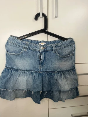 Blå volangkjol i denim - Oanvänd kjol från Gina, storlek 170 och midjemått rakt över är 39/40cm. Skriv om ni har några funderingar! 💕Kan tänka mig gå ner i pris. 