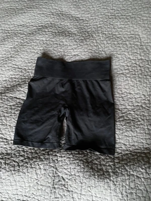 Svarta träningsshorts från FBsister - Svarta cykelshorts från FBsister med bred, ribbad midja för extra komfort. Tight passform och stretchigt material som passar perfekt till träning eller en aktiv vardag. Diskret logga på midjebandet baktill.