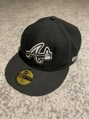Svart New Era 59FIFTY keps Atlanta - Snygg svart keps från New Era 59FIFTY med Atlanta Braves-logga broderad framtill i vitt. Klassisk flat peak och strukturerad passform. Märke på sidan.