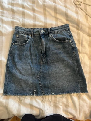 Jeans kjol - Säljer denna jeans kjolen från Gina Tricot då den blivit för liten. Den är i mycket bra skick och endast använd fåtal gånger. 