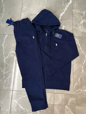 Marinblå loungewear-set från Polo Ralph Lauren - Marinblå tracksuit. Extremt fräsch och mysig. Passar i lounge, flygplats, träning.  Ett sett för allt. Jag fraktar omedelbart vid köp. Storleken är S men passar även M. 