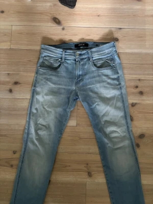 Ljusblå Replay Anbass jeans - Säljer ett par ljusblå Replay Anbass jeans med snygg tvätt och klassisk femficksmodell. Jeansen har smal passform och är tillverkade i mjukt denimtyg. Perfekta för dig som gillar en avslappnad men trendig stil.