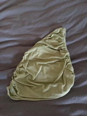 Ljusgrön one shoulder topp från SHEIN - Trendig ljusgrön one shoulder topp från SHEIN i stretchigt och mjukt material. Toppen har en asymmetrisk design med rynkade detaljer och sitter snyggt på kroppen. Perfekt för dig som vill ha en unik och stilren look.