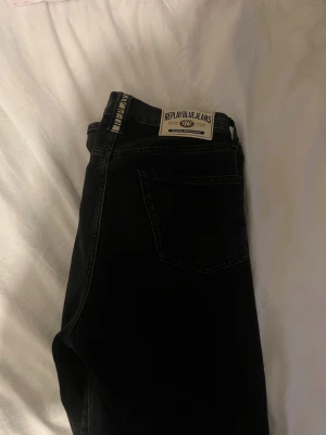 jeans Replay - Säljer ett par svarta jeans från Replay med klassisk femficksmodell och tydlig Replay Blue Jeans-lapp bak i midjan. Jeansen har raka ben och är tillverkade i ett slitstarkt denimtyg. Perfekta för en avslappnad och stilren look.