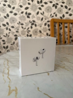 Apple AirPods Pro 2 - Säljer ett par Apple AirPods Pro i originalförpackning. Vita, stilrena in-ear hörlurar med silikonproppar och aktiv brusreducering. Kommer i en kompakt, vit box med Apple-logga. Perfekta för musik, samtal och gaming.
