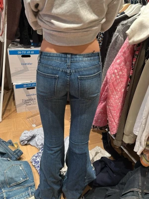 Blå bootcut jeans med fickor - Säljer ett par blå bootcut jeans med markerade sömmar och stora bakfickor. Jeansen har en klassisk femficksmodell och är tillverkade i denim med lätt stretch. Perfekta för dig som gillar en retroinspirerad look med utsvängda ben.