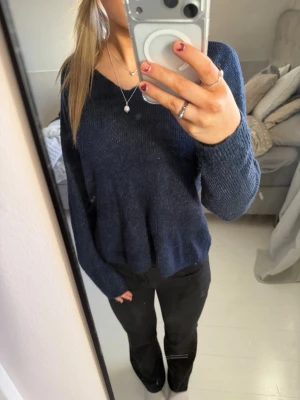 Mörkblå stickad tröja med v-ringning - ( SMUTSIG SPEGEL) Mysig mörkblå stickad tröja med v-ringad hals och långa ärmar. fin mörkblå färg, mysig att ha på sig, men samtidigt ser den väldigt uppklädd ut.  storleken är XS, men man kan även ha den om man är s/m person!! använt den fåtal gånger så den är inte nopprig!!