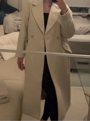 Beige ullkappa med slagkrage - Stilren beige kappa i ullmix med klassisk slagkrage och dubbelknäppning. Stor i storlek och passar från xs-L💕 original pris 699kr! 