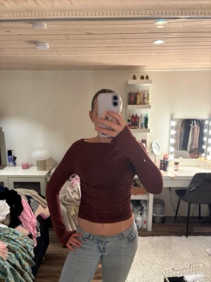 Mörkröd långärmad topp från Stories - Snygg mörkröd långärmad topp från & Other Stories. Modellen är tight och croppad med rund halsringning. Tillverkad i ett mjukt och stretchigt material som sitter skönt mot kroppen. Perfekt att styla med jeans eller kjol.