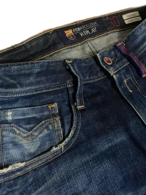 Replay anbass jeans - Snygga mörkblå jeans från Replay med raka ben och klassisk femficksmodell. Jeansen har slitningar och tvättade detaljer för en cool look. Tillverkade i denim med kontrastsömmar och logga på bakfickan.