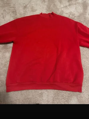 Röd sweatshirt bershka  - En enkel och stilren röd crewneck sweatshirt med rund halsringning och ribbade muddar vid ärmslut och nederkant. Perfekt för dig som gillar en clean look. Materialet känns mjukt och bekvämt, troligen bomull eller bomullsblandning. Inga synliga loggor eller tryck.