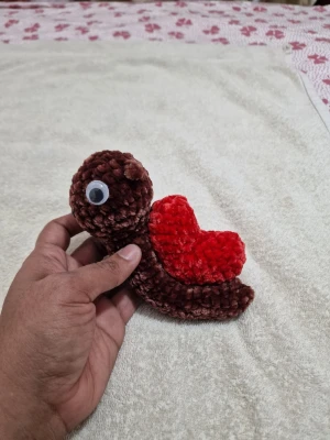 Virkat mjukisdjur sköldpadda brun/röd - Söt handvirkad sköldpadda i mjukt garn, brun kropp och huvud med ett rött hjärtformat skal. Har ett stort plastöga som detalj. Perfekt som dekoration eller present till någon du gillar.