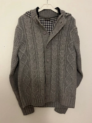 Fodrad cardigan - Hej nu säljer vi denna grymt feta Olly Gan fodrade cardigan i en stilren grå färg som lätt gör att klä sig bra i. Skicket 9/10 inga defekter. Storleken: (4)≈M/L Bröstlängd: 50cm. Midjalängd: 50cm. Längd:65cm. Armlängd: 65cm. För fler frågor hör gärna av er så hörs vi!